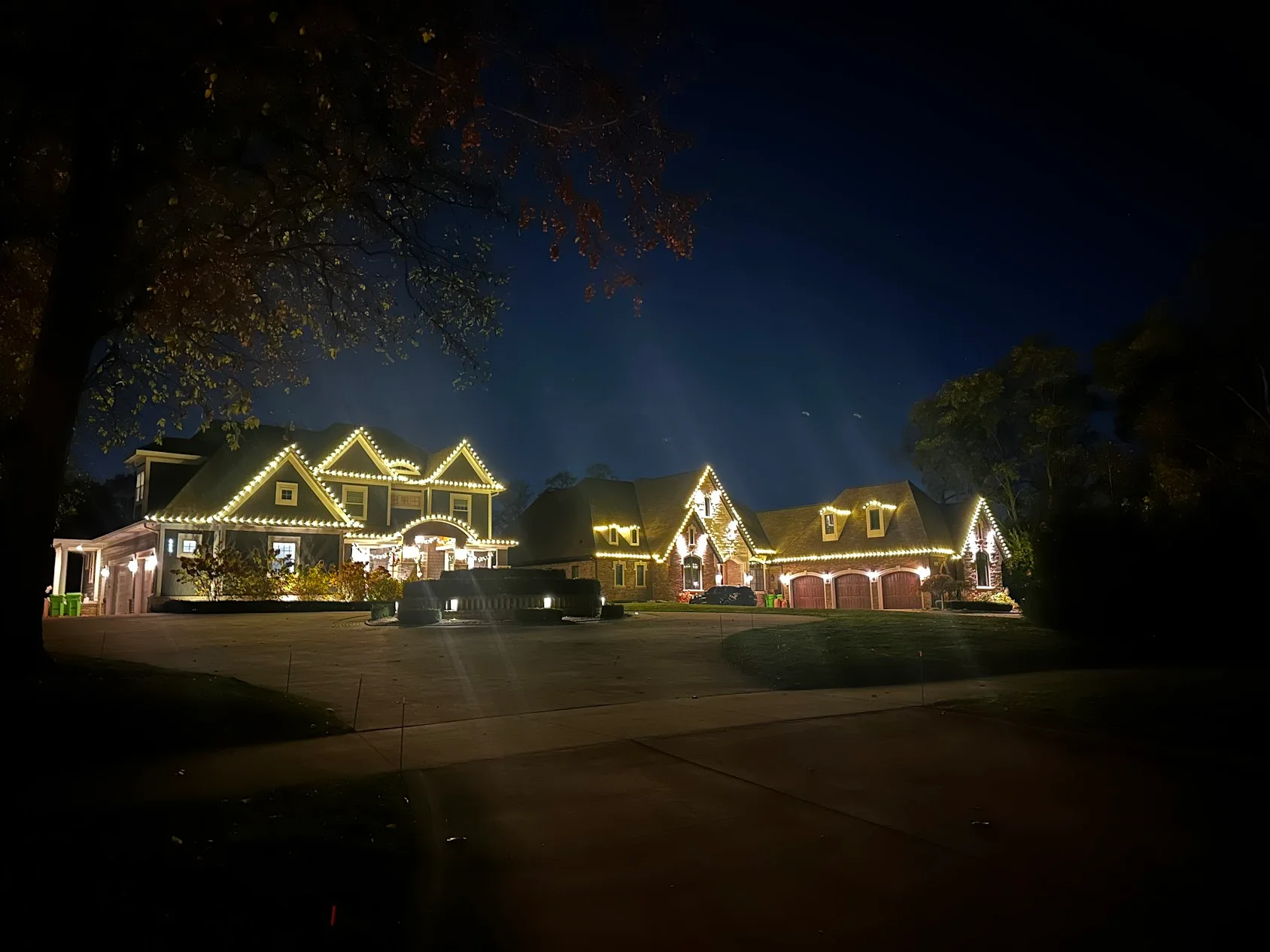 Brick home at night with warm LED lighting outlining rooflines and architectural features