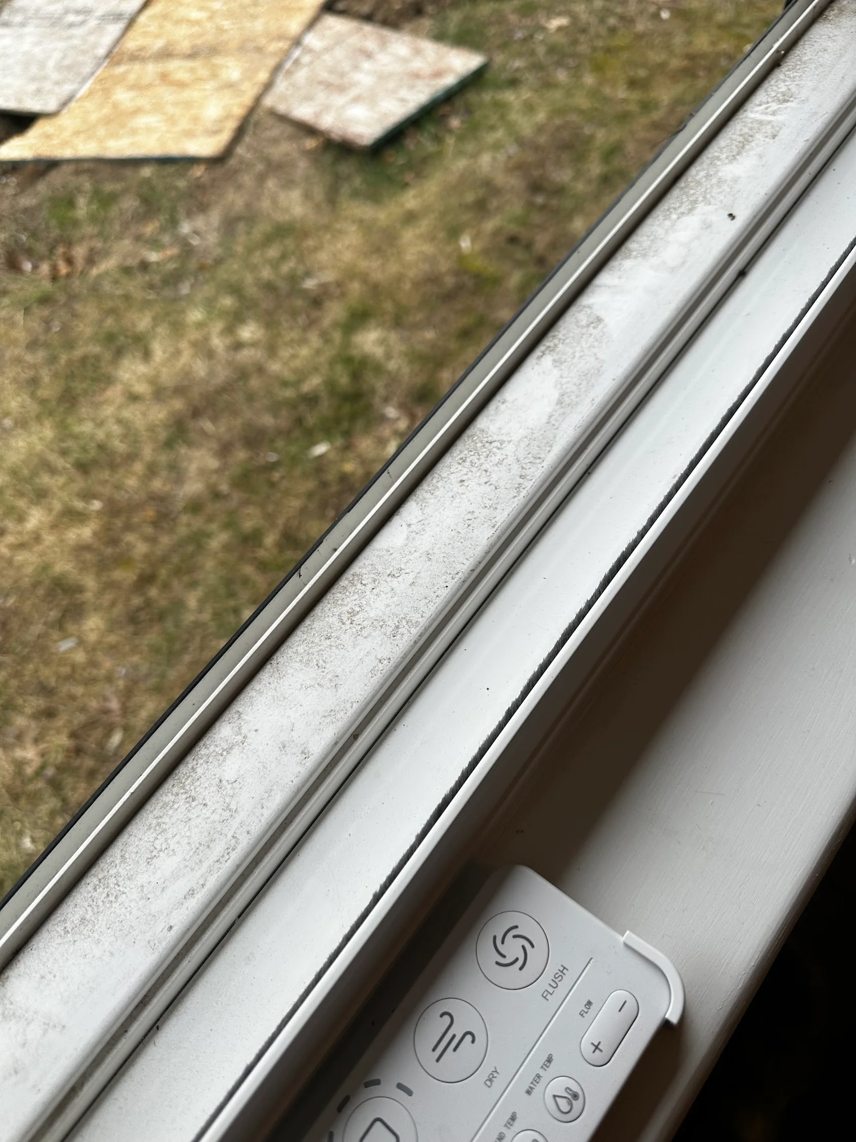 Cleaned aluminum gutter and window frame with control panel visible, showing dirt removal results