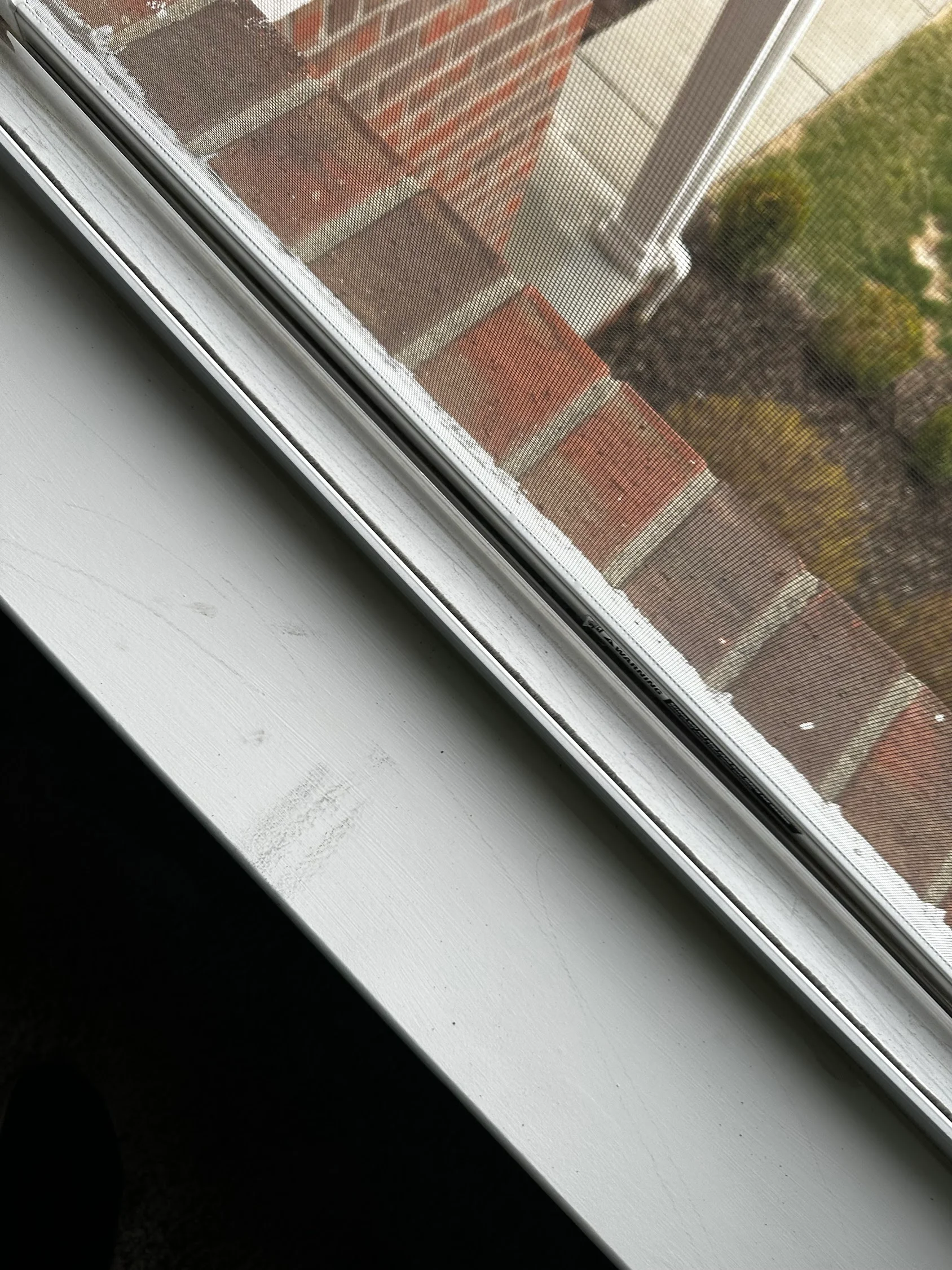 Clean white vinyl window frame and sill with restored appearance after pressure washing service
