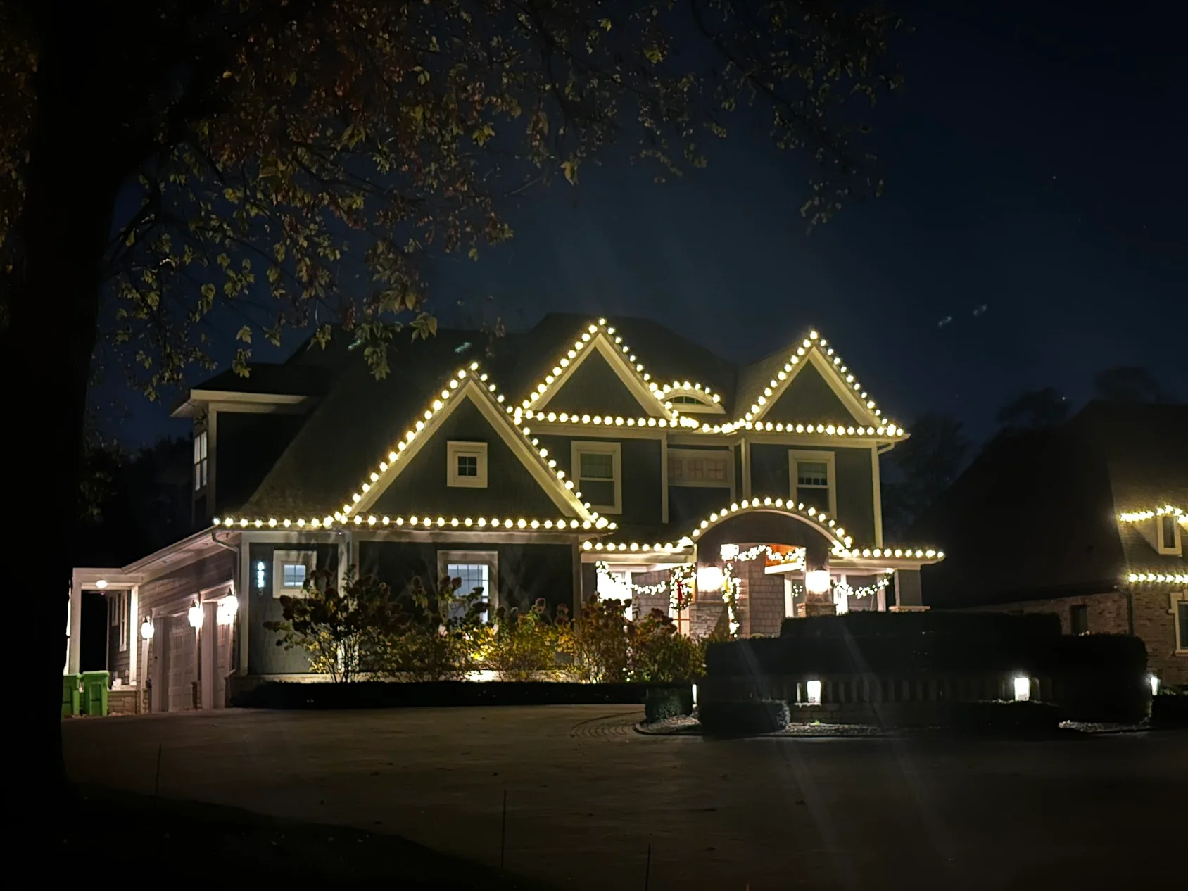 Two-story home at night with warm LED rope lighting outlining rooflines and gables